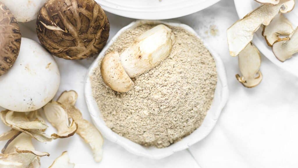 Mushroom powder on a plate with fresh mushroom in. 