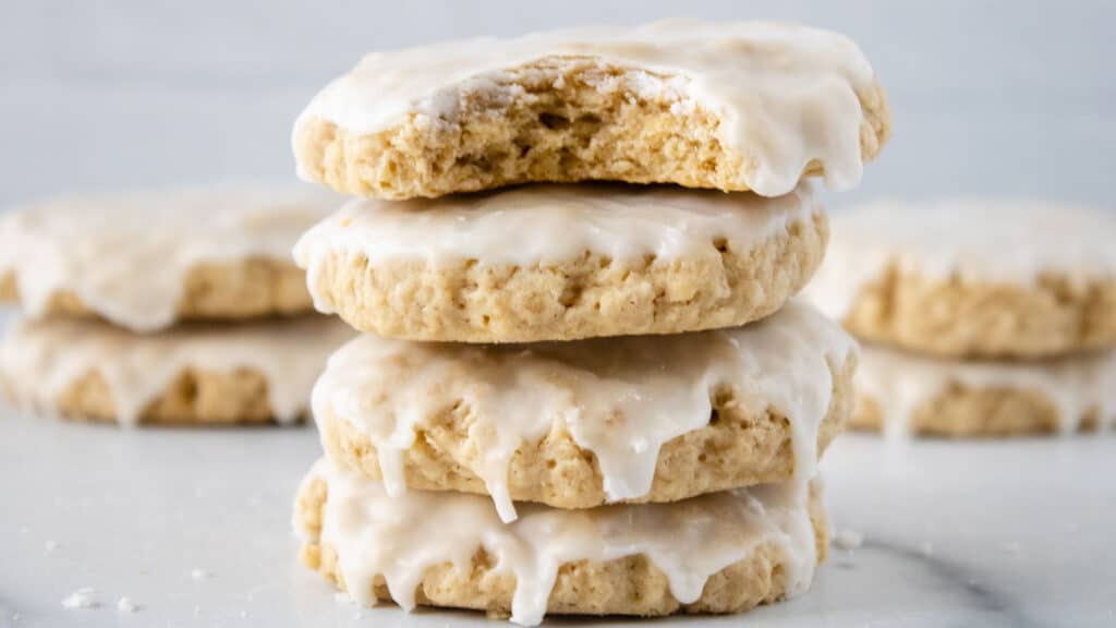 Four iced oatmeal cookies stacked.