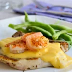 Bone in pork chops and succulent shrimp pair with an amped-up hollandaise sauce for a fun spin on summer grilling in this Grilled Pork Chop Surf and Turf.