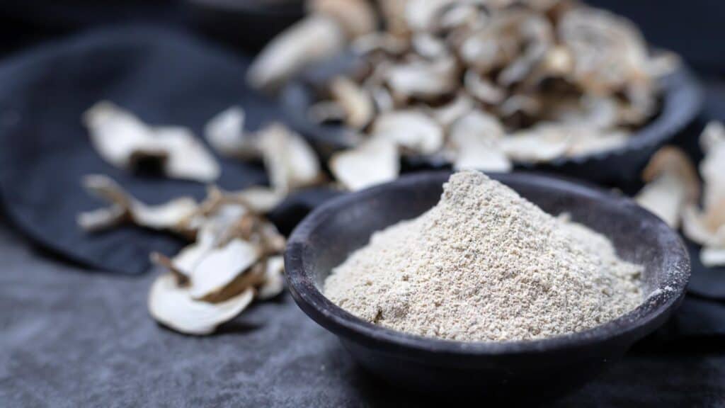 Mushroom powder inside a dark bowl. 