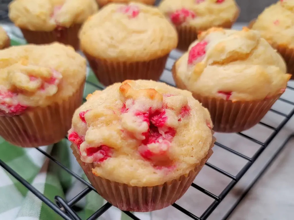 Raspberry muffins cooling on a wire rack.