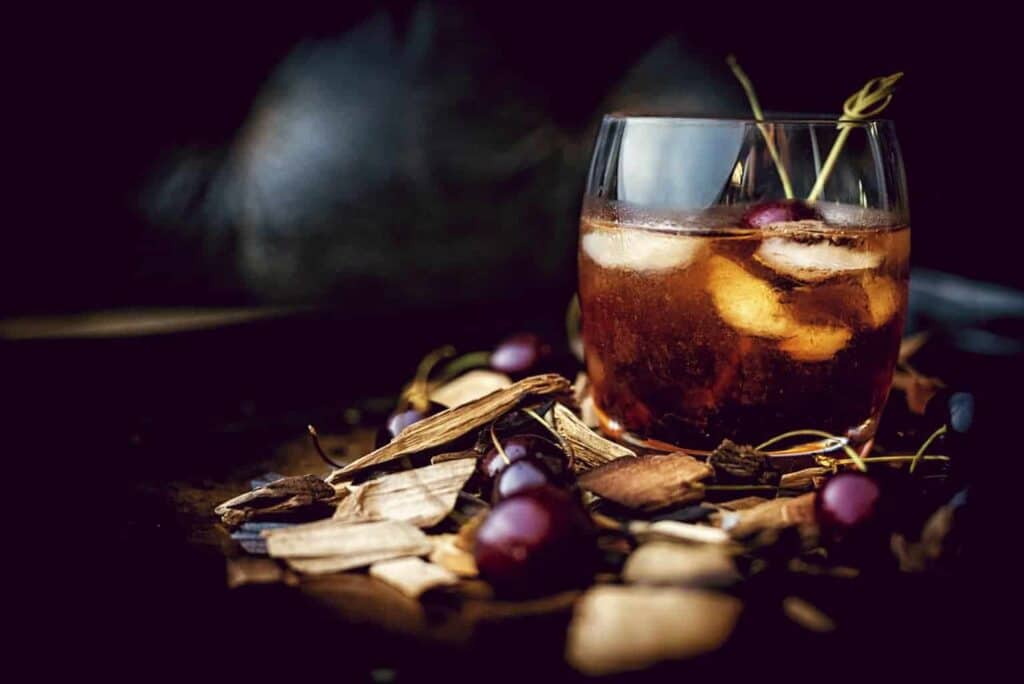 Dark and moody smoked old fashioned cocktail. 