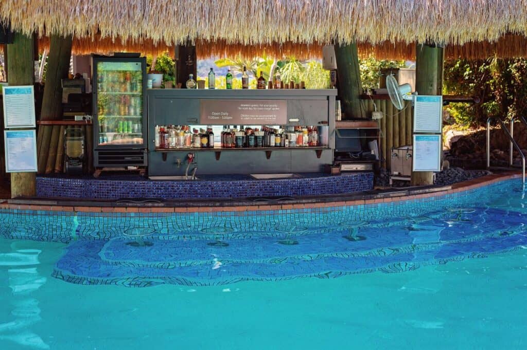 A swim up cocktail bar in the middle of a pool on a luxury island resort.