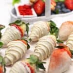 White Chocolate Covered Strawberries on a white wooden board.
