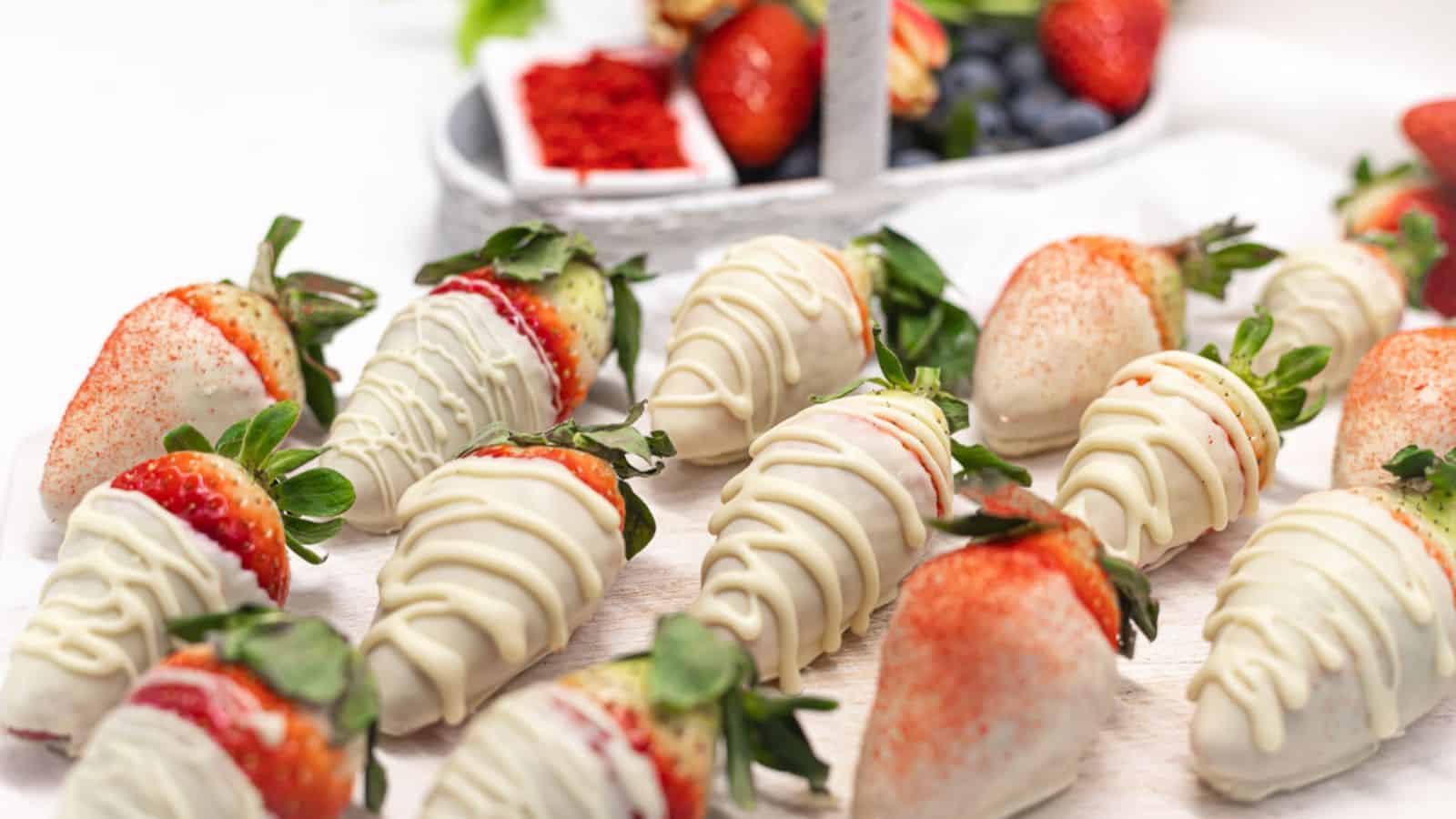 White Chocolate Covered Strawberries on a white wooden board. 