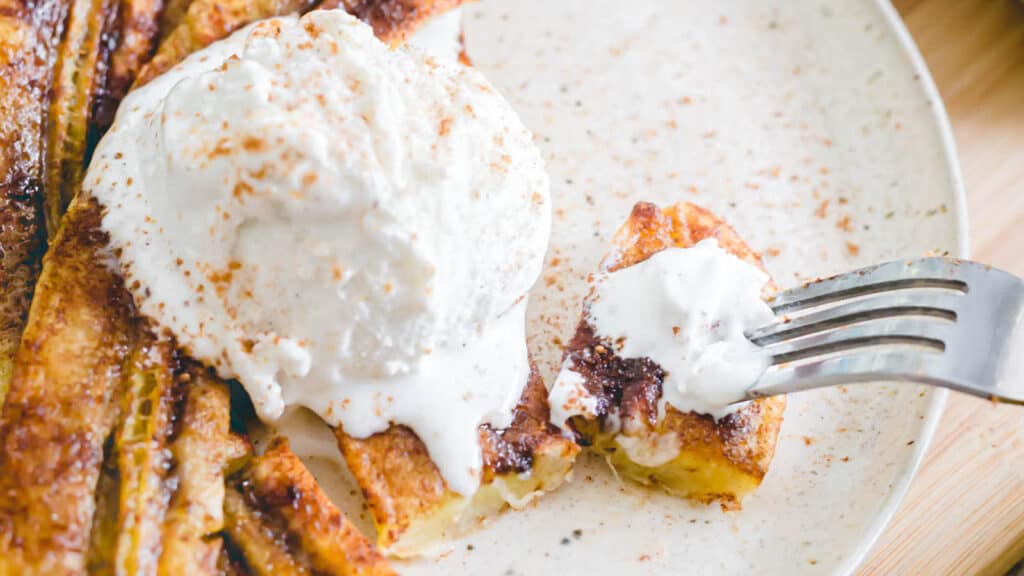 Air fryer caramelized bananas on a plate with vanilla ice cream.