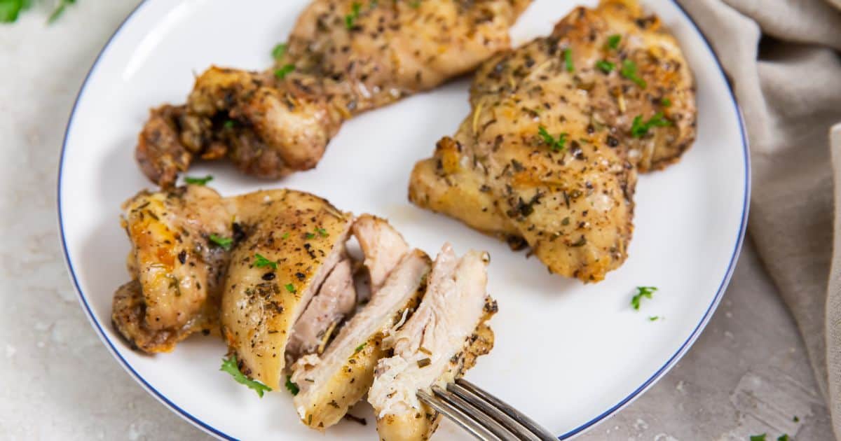 Easy Air Fryer Boneless Skinless Chicken Thighs on a white plate with parsley.