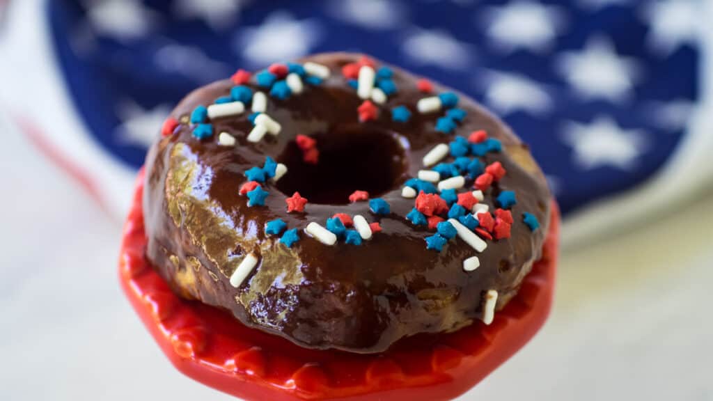 Air fryer donuts with chocolate glaze and patriotic sprinkles.