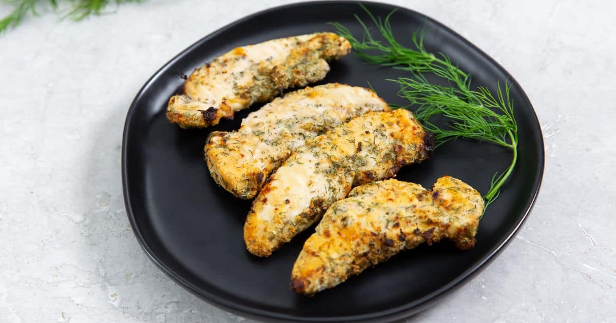 Easy Air Fryer Ranch Chicken Tenders on a black plate with dill.