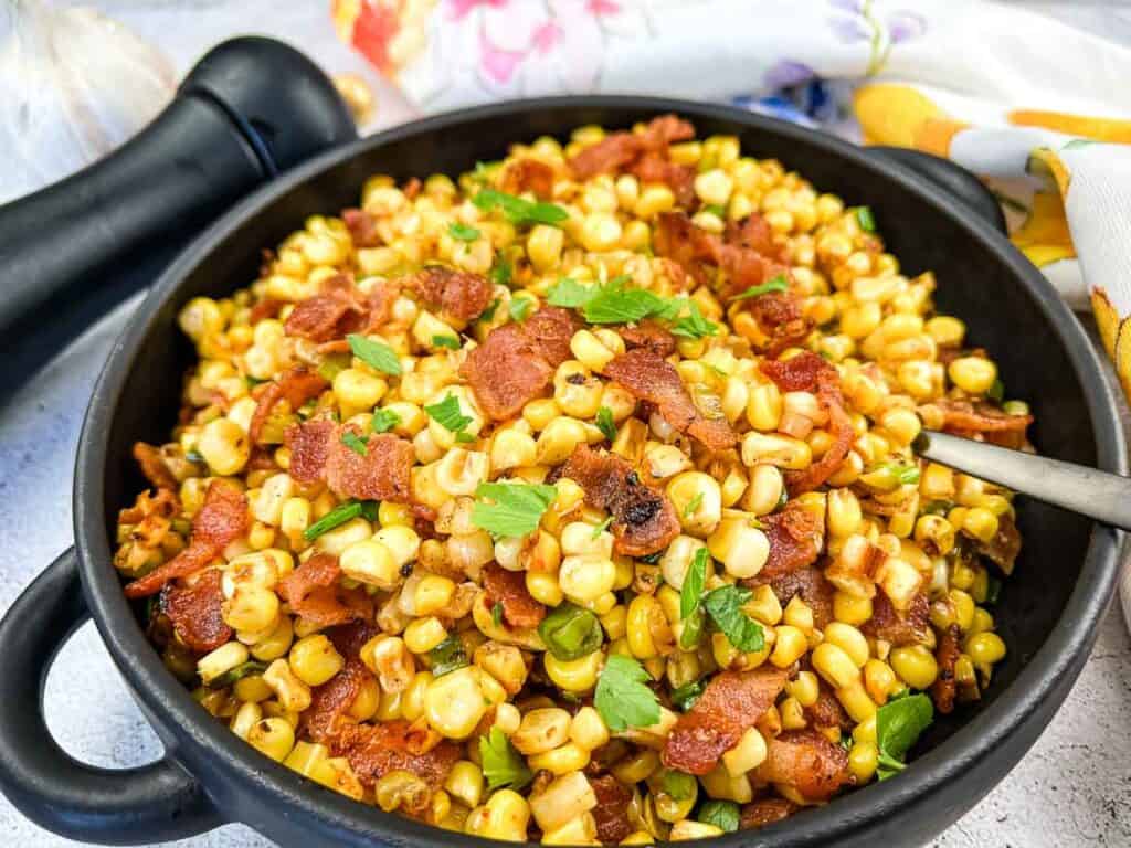 Bacon-Fried Corn in a black serving bowl.