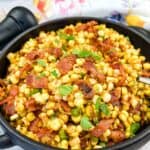 Bacon-Fried Corn in a black serving bowl.