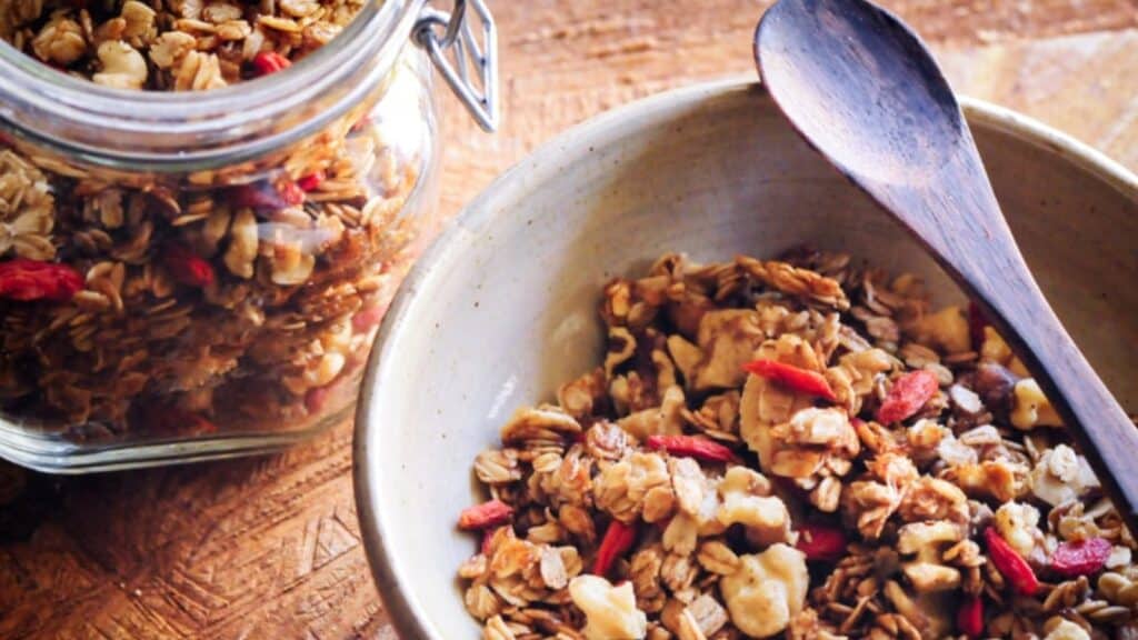 A bowl and jar filled with homemade granola.