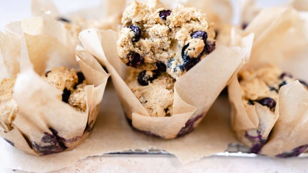 Close shot of blueberry muffins wrapped in parchment paper.