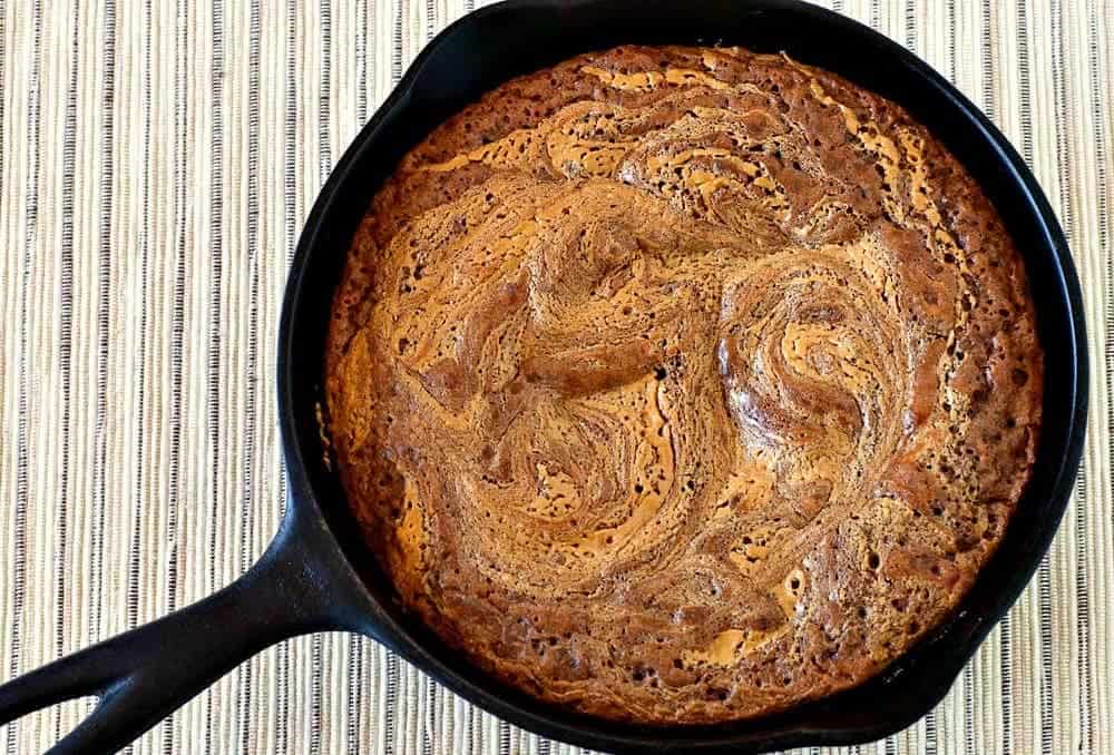 Top view of a a chocolate peanut butter cake in a cast iron skillet.