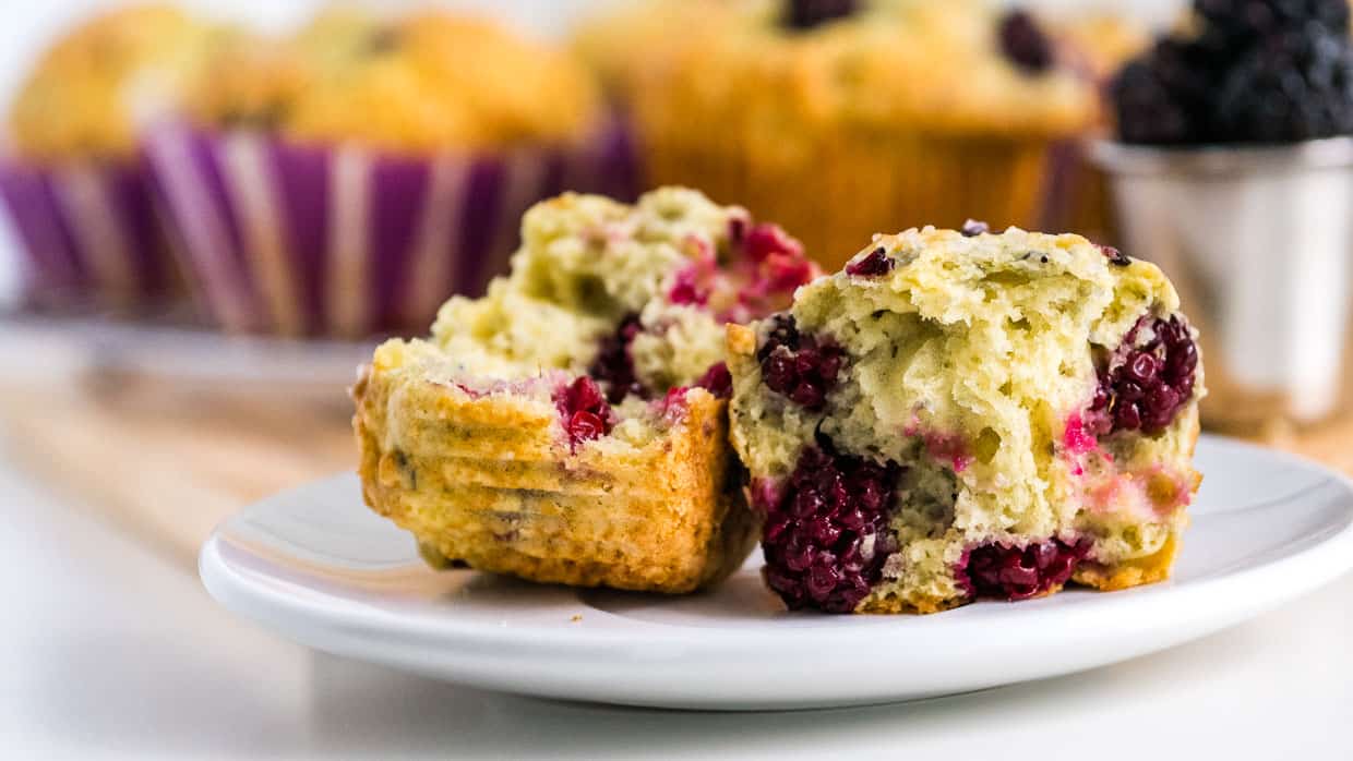 Blackberry muffins broken in half to show the berries.