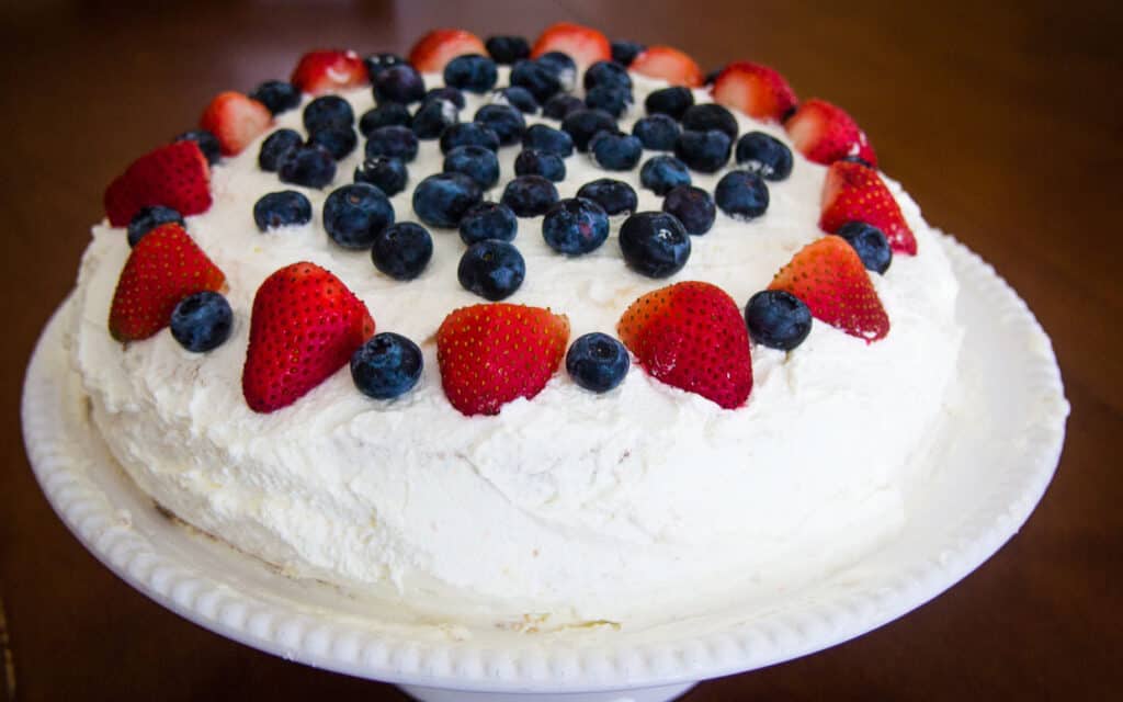 Norwegian cream cake topped with strawberries and blueberries.