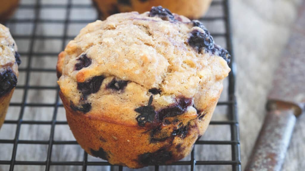 Whole wheat blueberry ginger muffins on cooling rack.