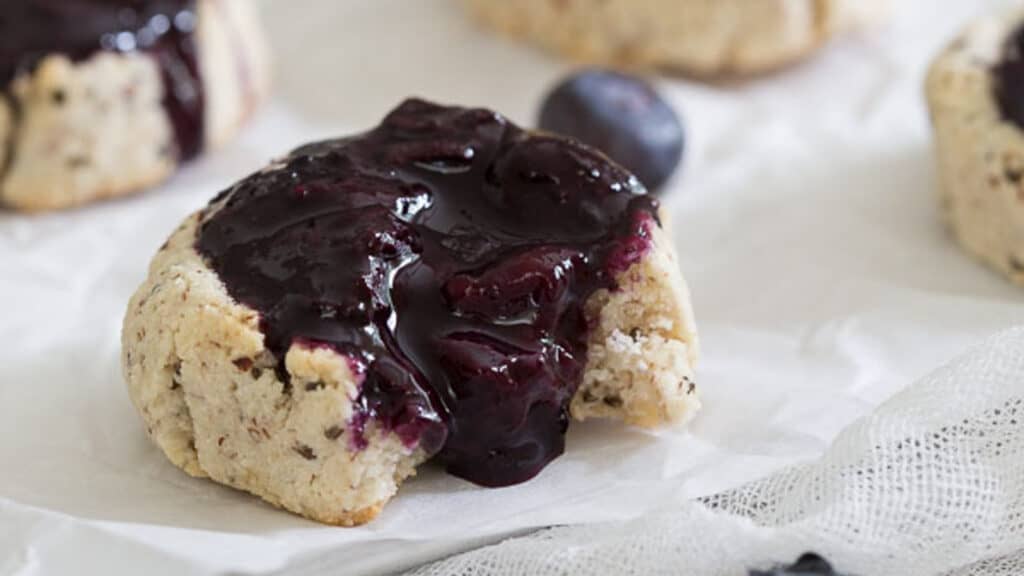 Blueberry thumbprint cookie on parchment paper.