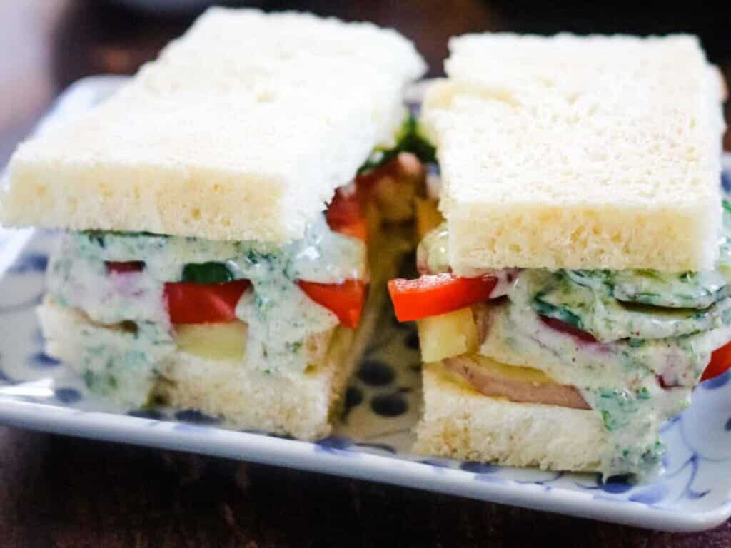 Bombay Sandwiches layered with potato, tomato, cucumbers, and an herb chutney sauce.