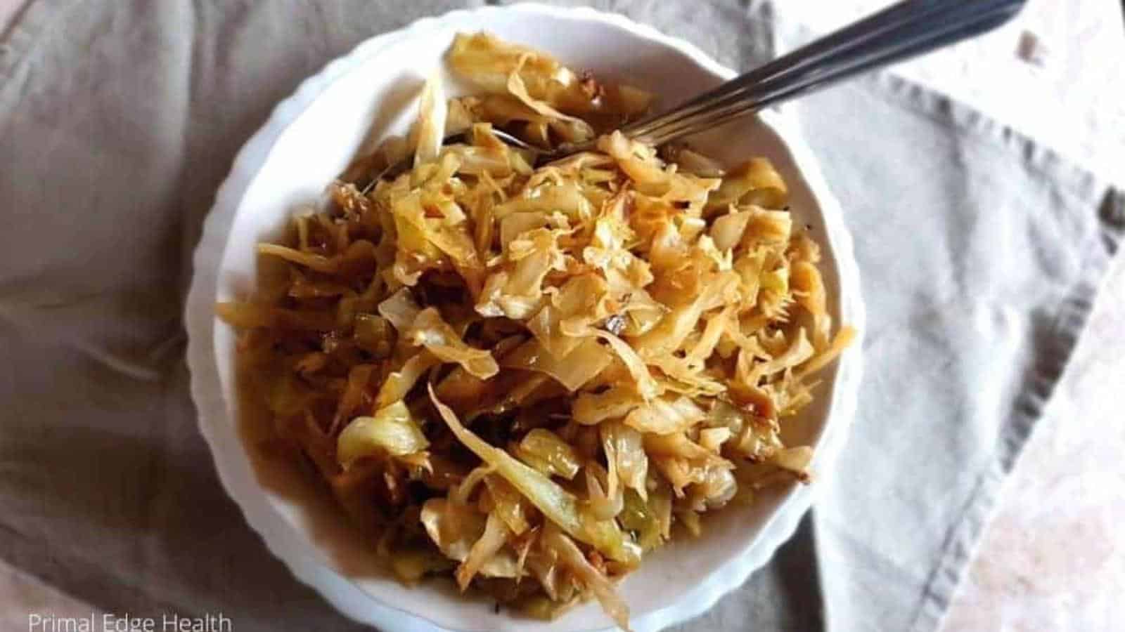Braised cabbage in bowl with spoon.