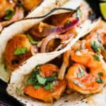 Shrimp tacos with lime wedges.