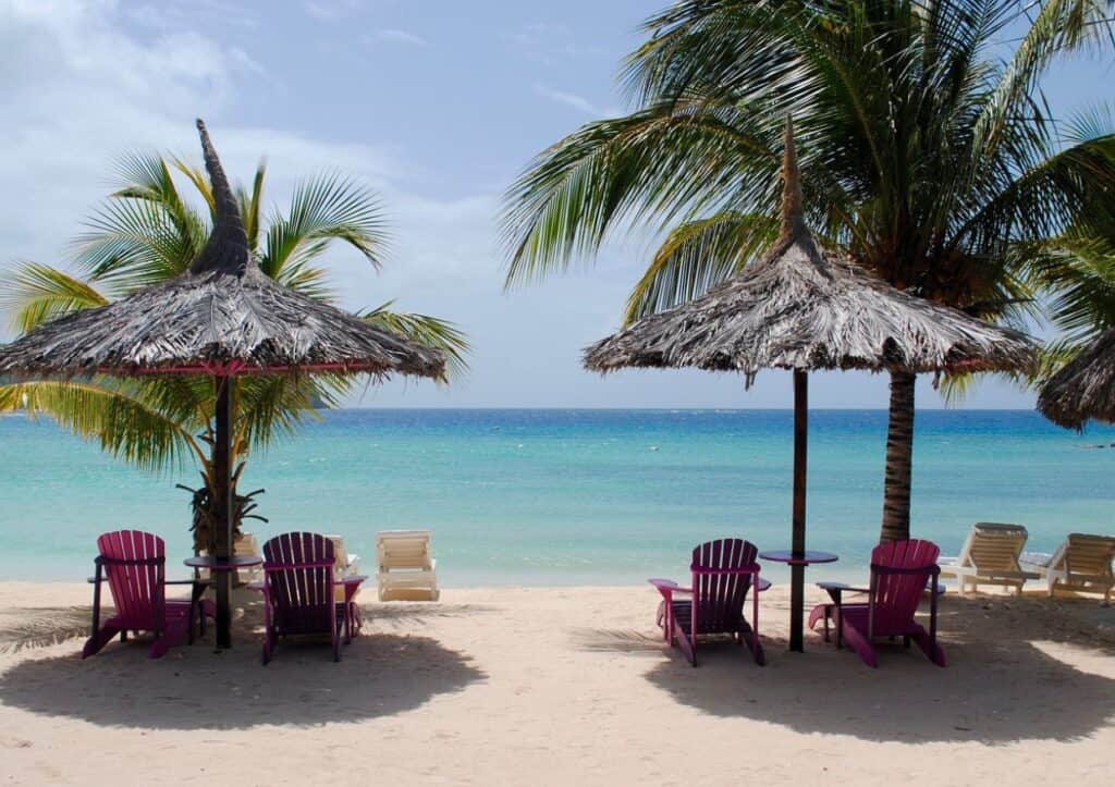Caribbean beach with beach chairs and palm umbrellas