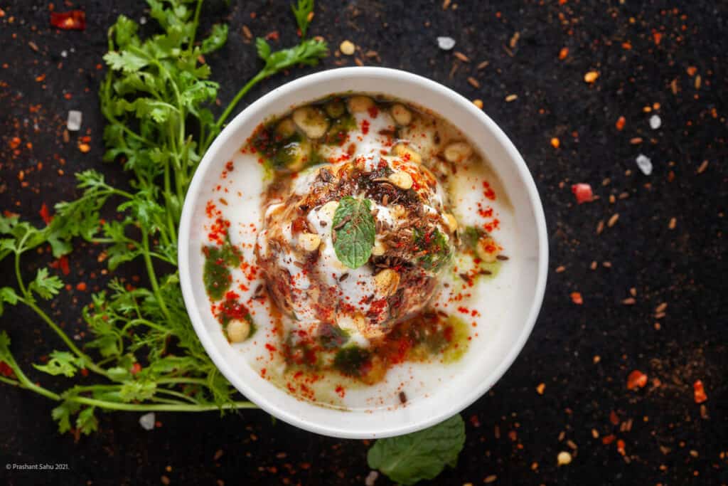 Chaat dahi vada with cilantro and peppercorns.
