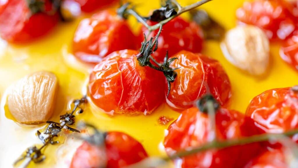 Close shot of cherry tomatoes resting in oil.