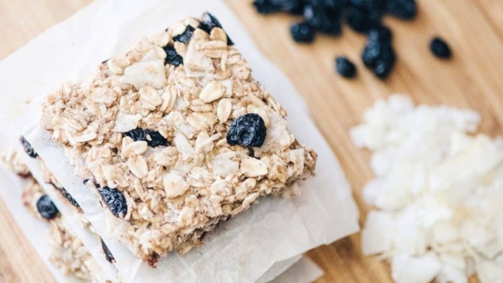 A stack of oatmeal bars resting on a wooden cutting board.