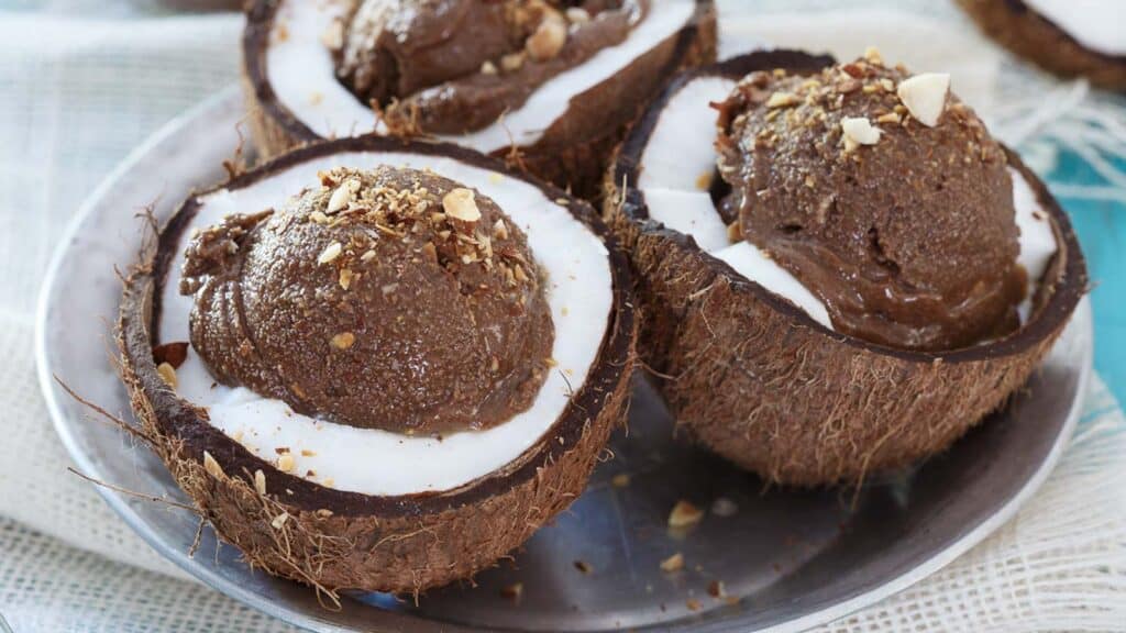 Chocolate coconut avocado ice cream in coconut shells.