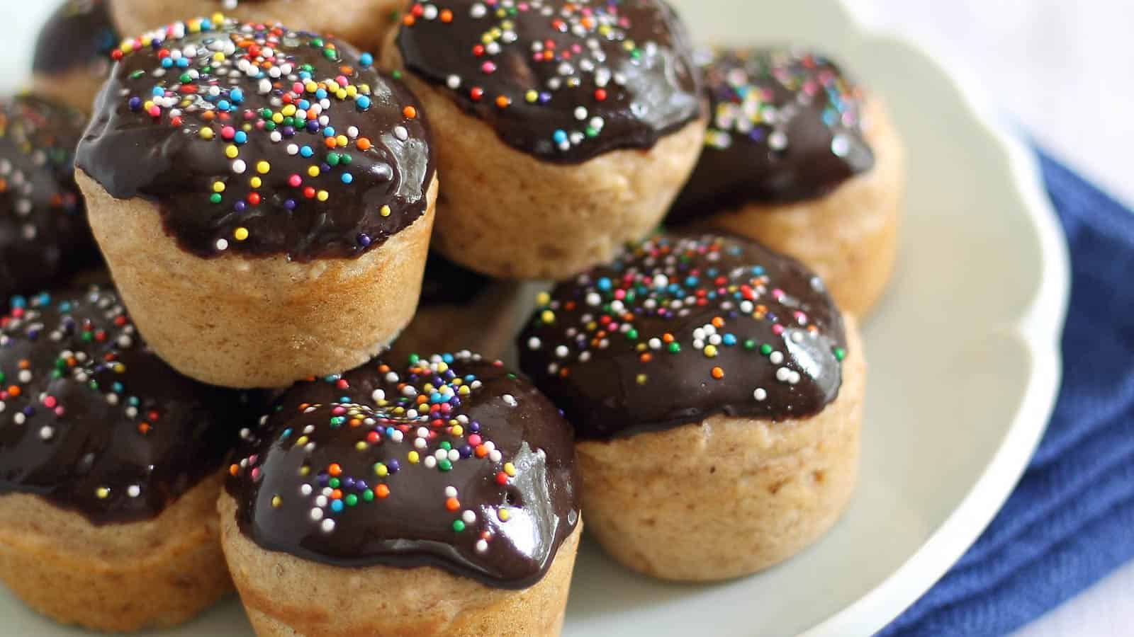 Chocolate glazed donut bites with rainbow sprinkles.
