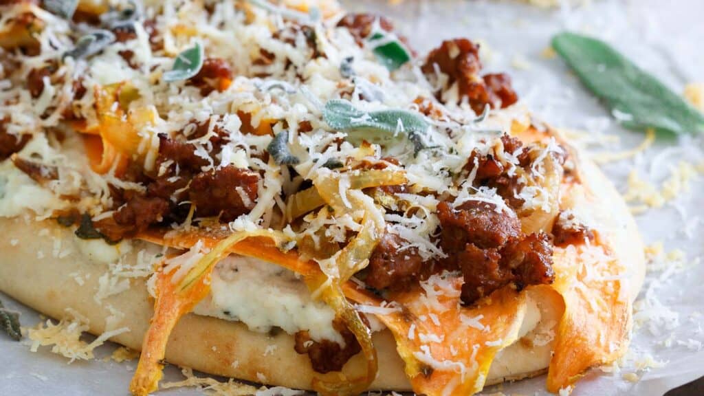 Chorizo naan pizza on parchment paper.