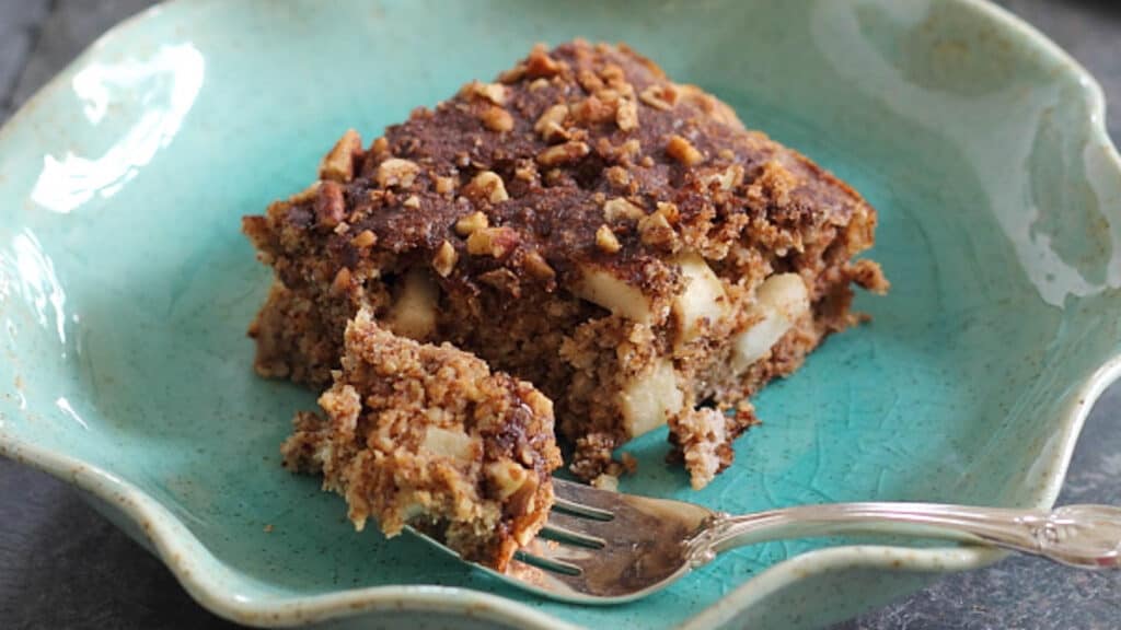 Apple cinnamon sugar cake with a fork on a teal plate.