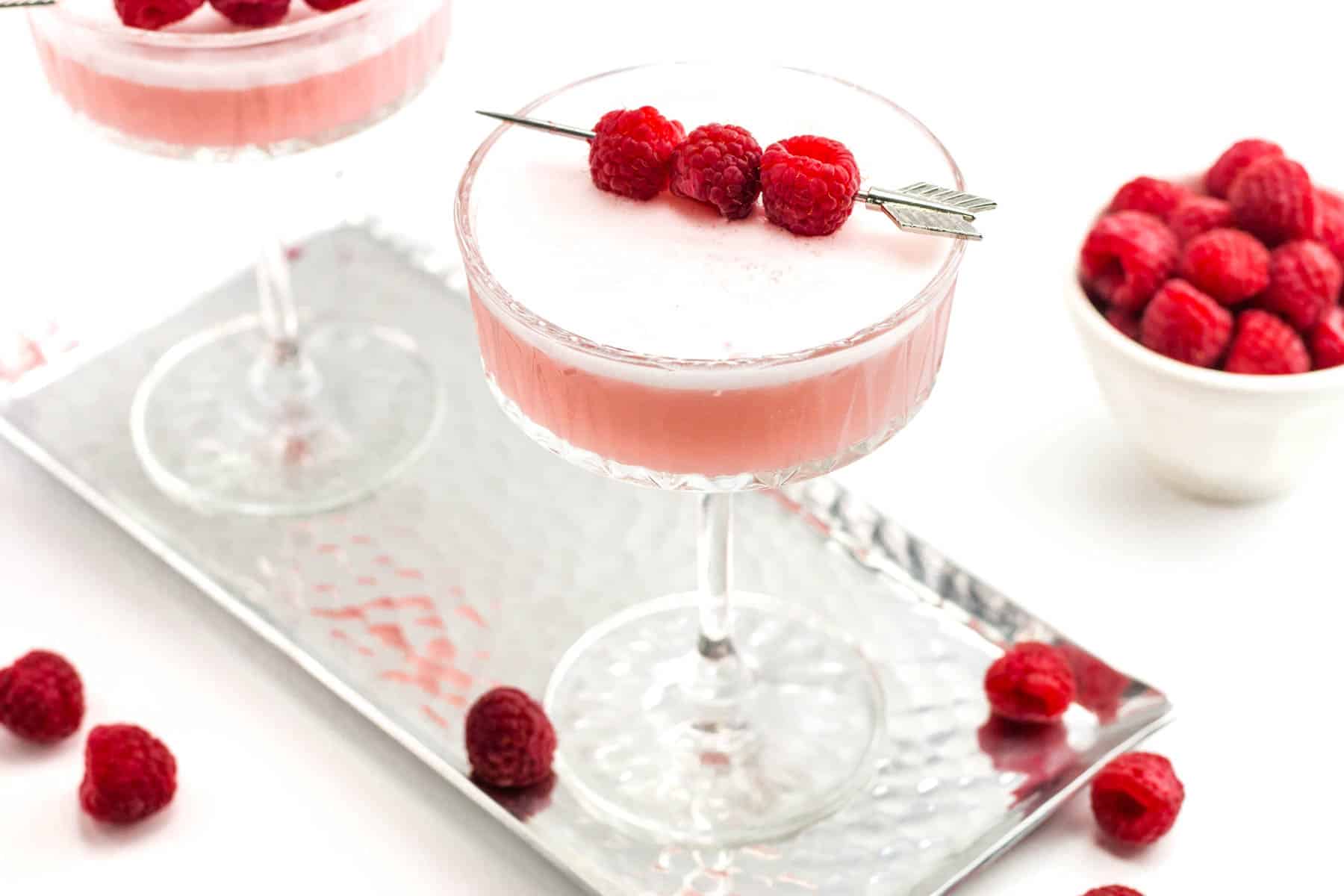 two clover club cocktails on a hammered silver tray.