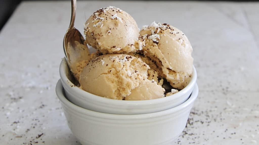 Coconut coffee ice cream scooped into stacked white bowls.