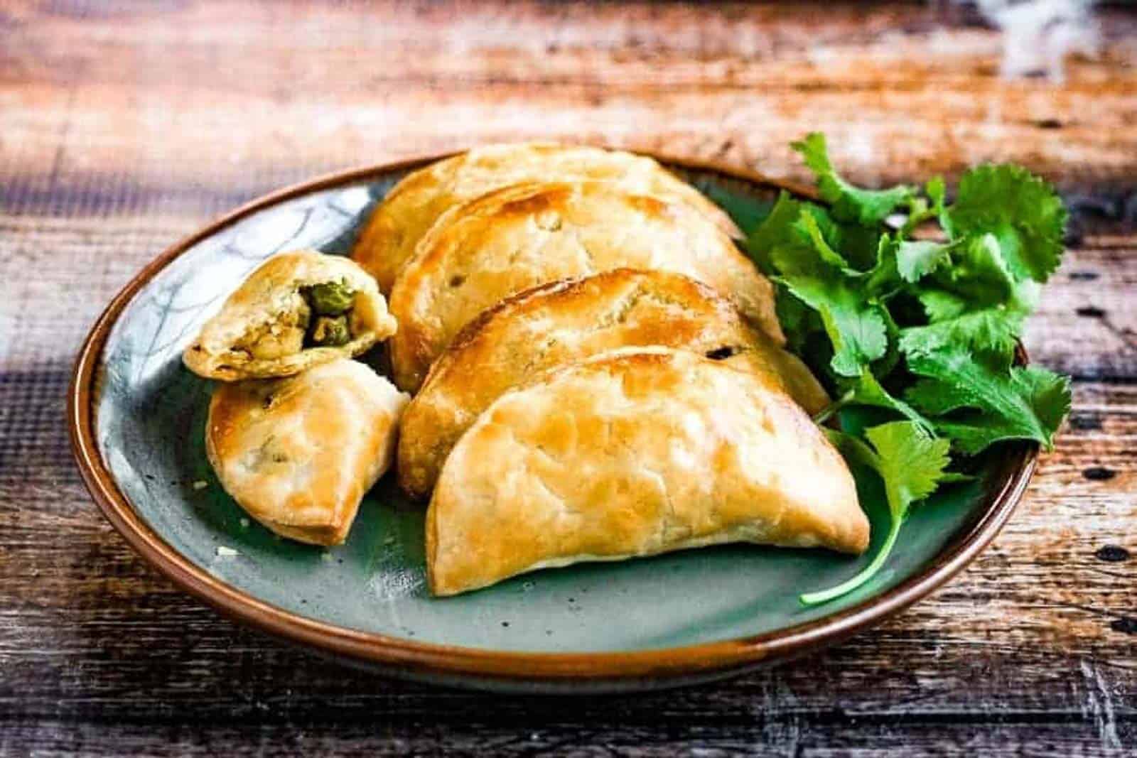 Thai  curry puffs on a plate with cilantro.