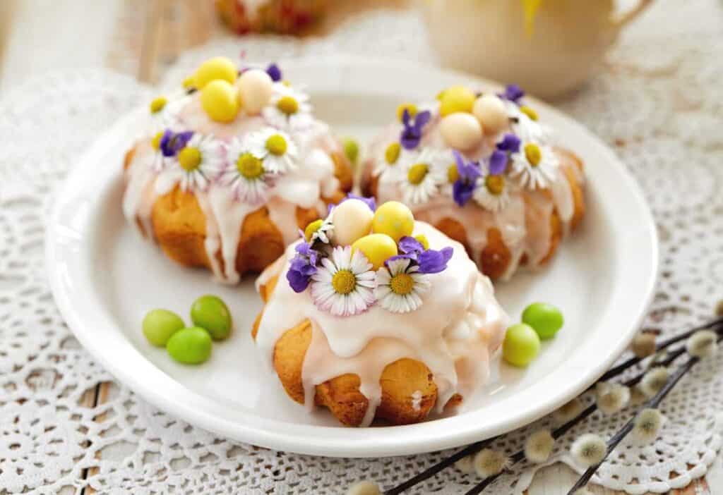 A white plate topped with cakes garnished with edible flowers.