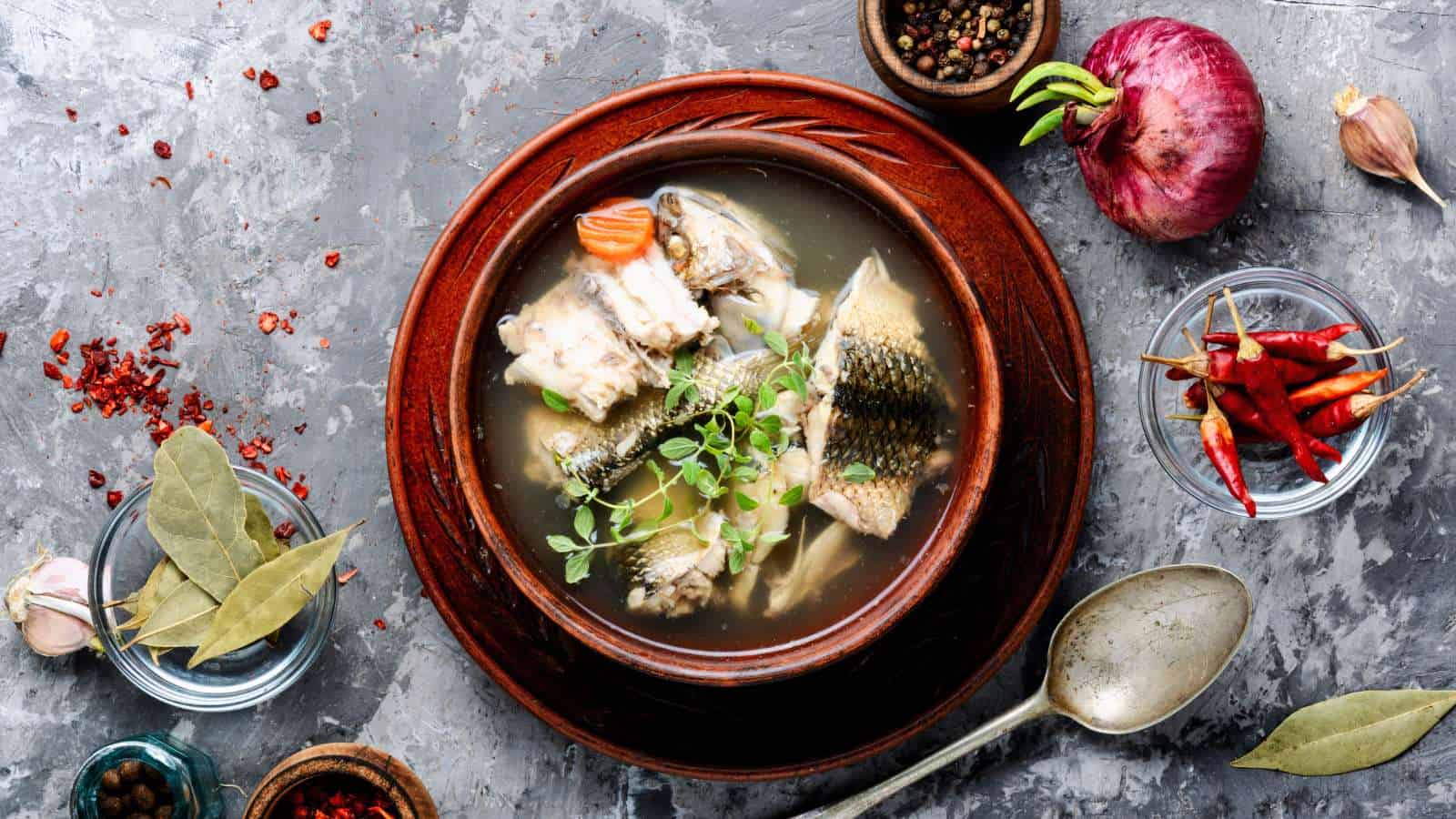 Fish stock in bowl with ingredients around.