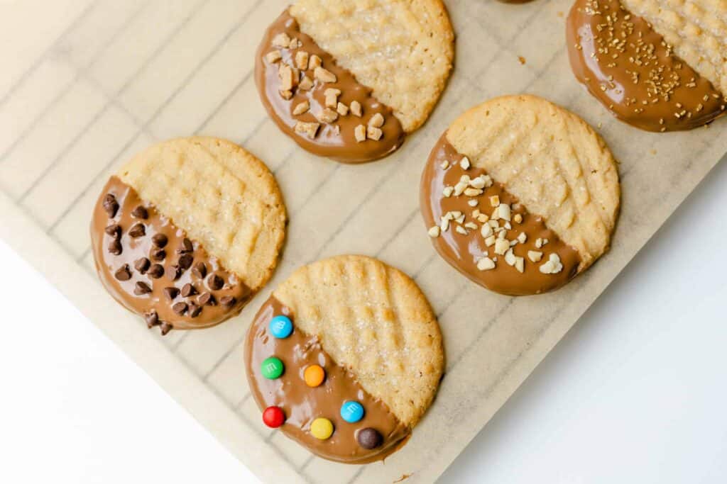Tray with chocolate dipped peanut butter cookies with various sprinkles.