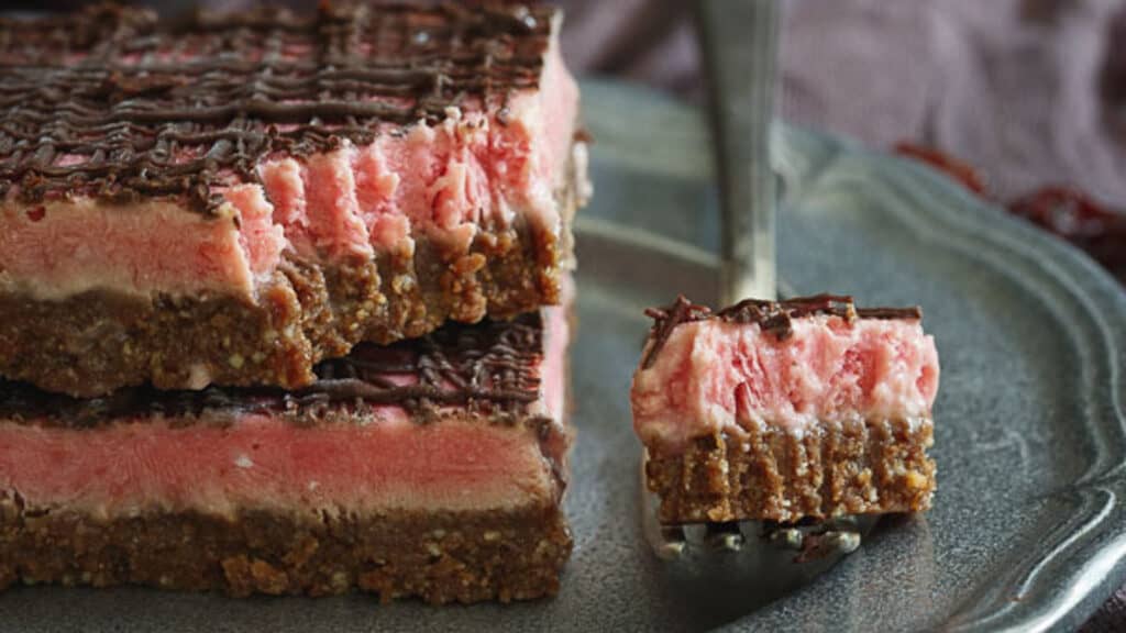 Frozen cherry chocolate bars on a metal plate with a fork.