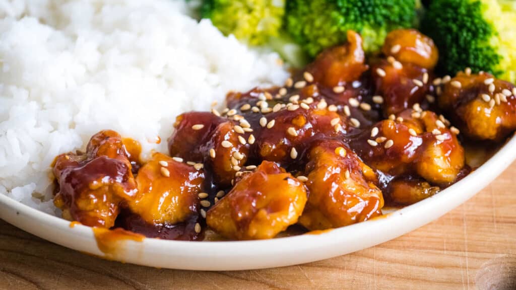 General Tso's Chicken on a plate with broccoli and rice.