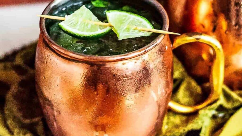 A copper cup filled with ice and lime wedges.