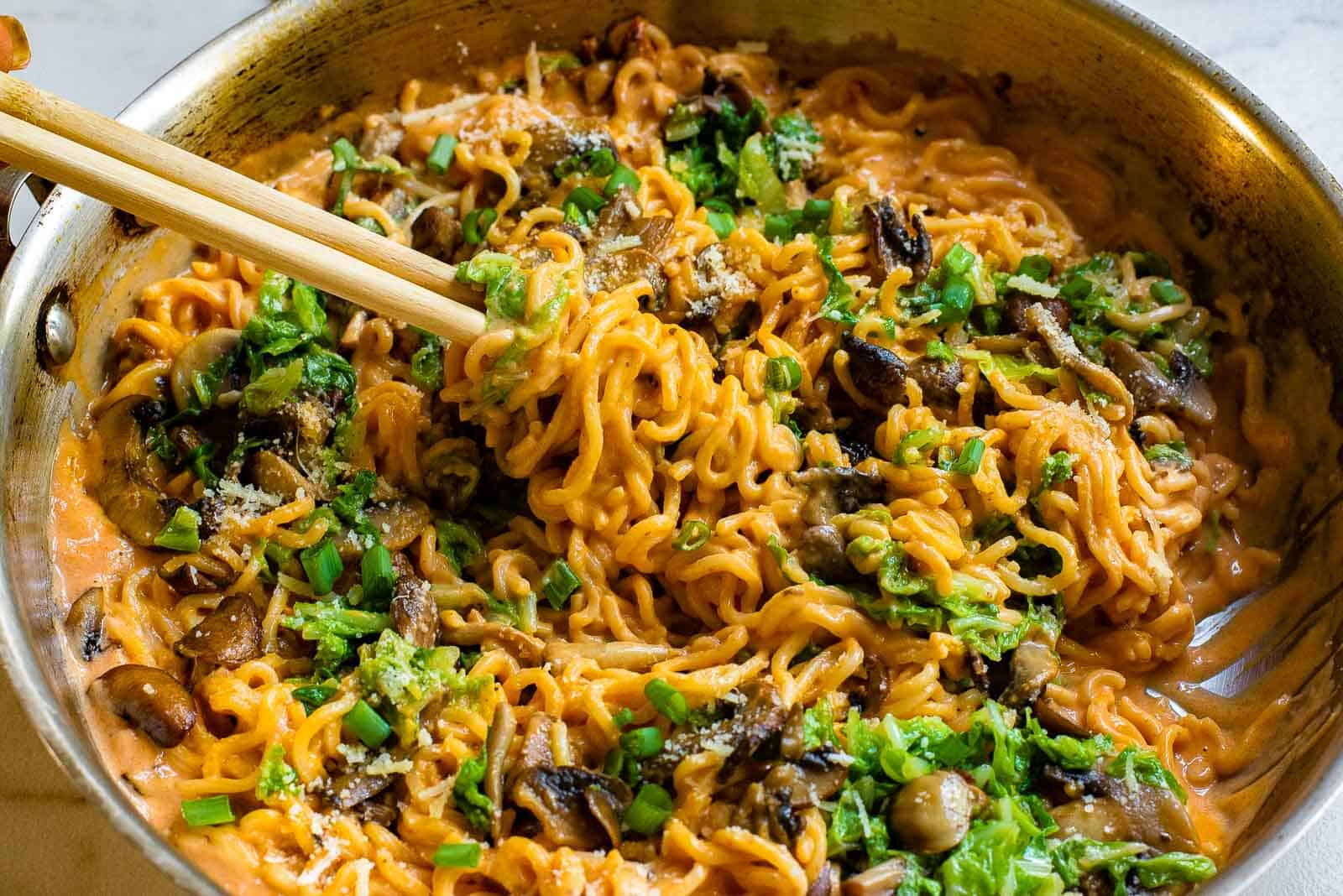 Gochujang noodles in a skillet with chopsticks.