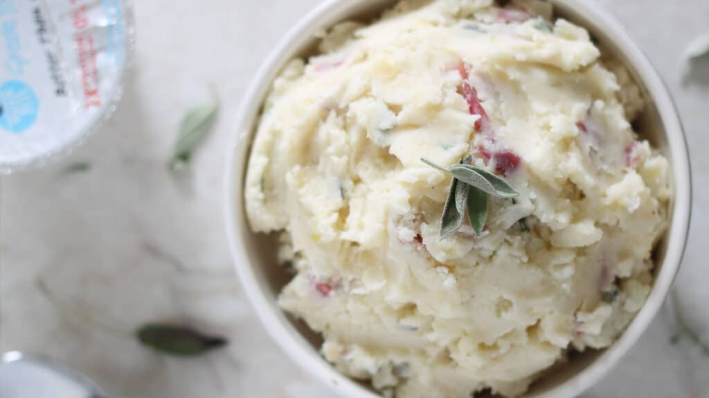 Smashed Greek yogurt potatoes in a white bowl.