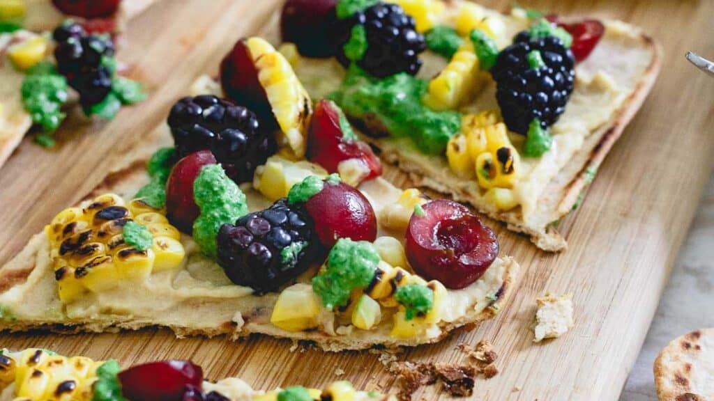 Grilled hummus flatbread with fruit and corn.