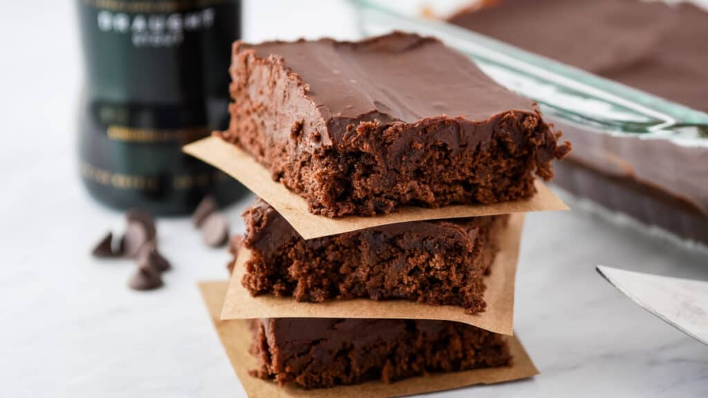 Stack of Guinness brownies with a bottle of Guinness in the background.