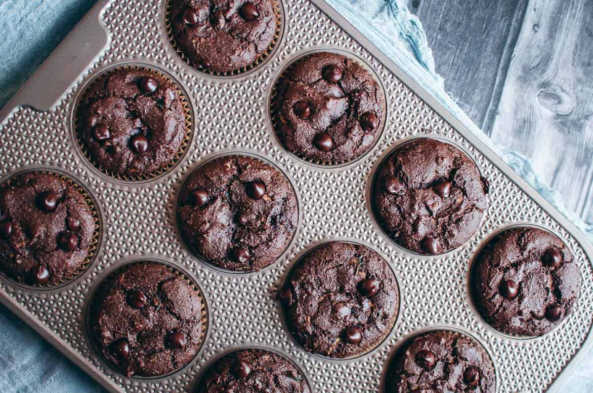 A baking tray with 12 chocolate zucchini muffins.