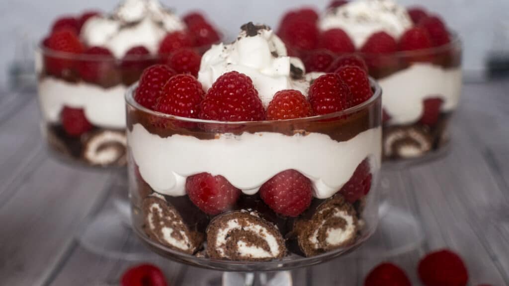 No bake dessert trifle with Ho Hos, raspberries, pudding and whipped topping.