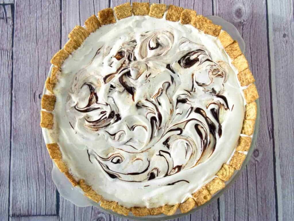 Top view of ice cream pie with cinnamon cereal crust and swirls of hot fudge.