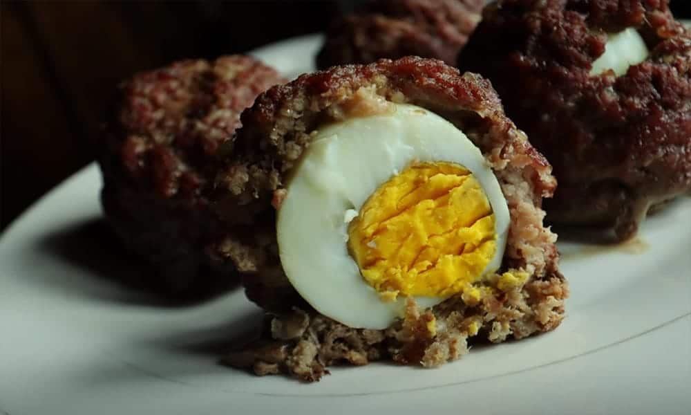 Keto scotch eggs with ground beef one cut in half.
